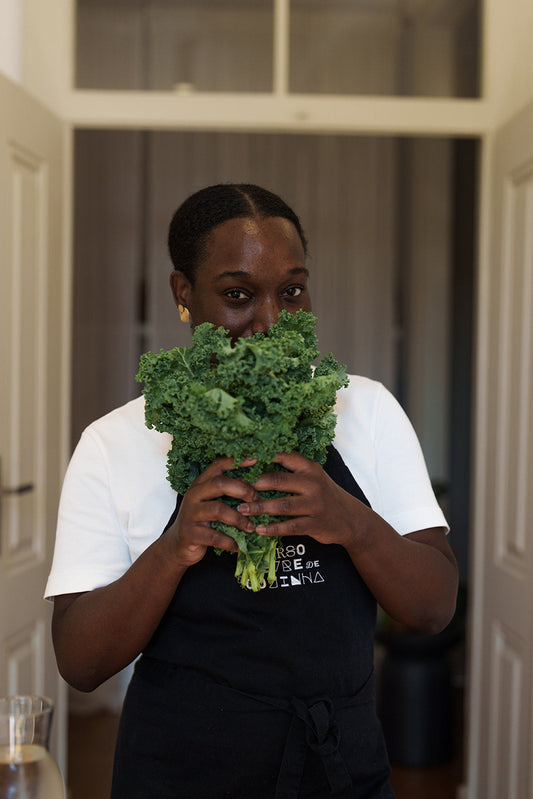 Woman holding fresh kale, a mineral-rich alkaline green that supports a natural Dr. Sebi detox