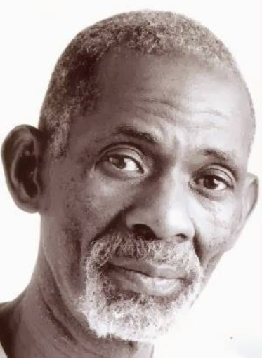 Portrait of an older man with gray beard and close-cropped hair against a white background.